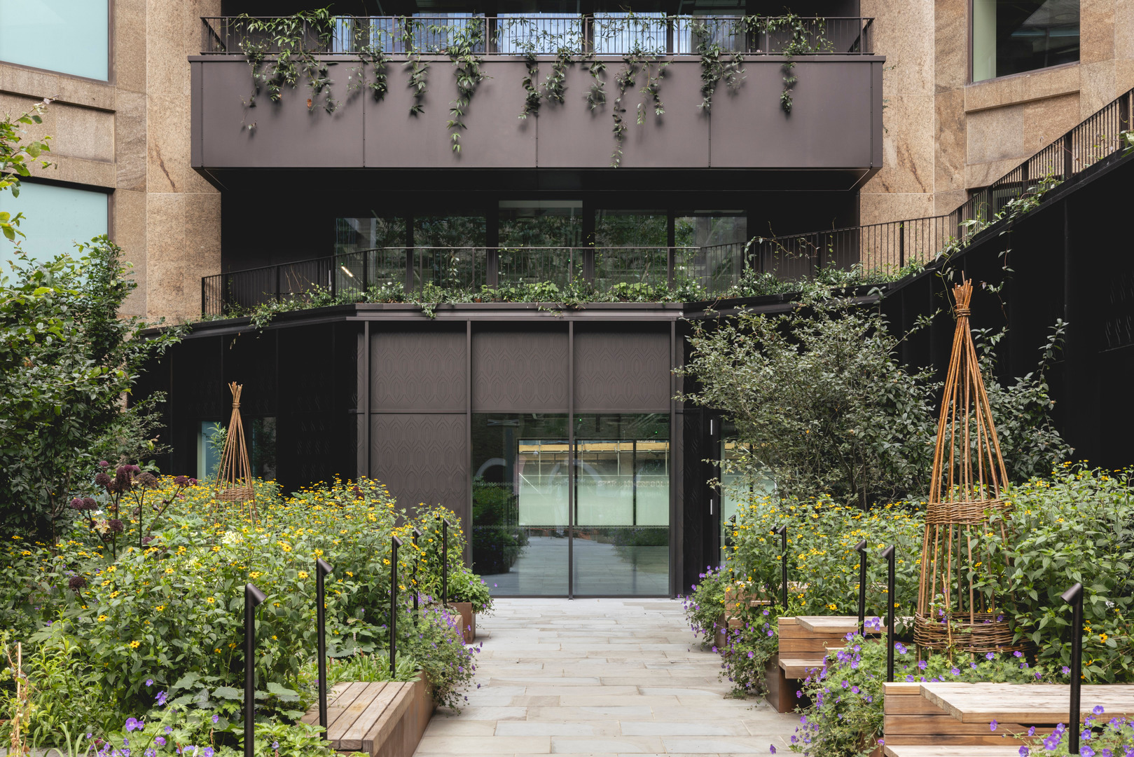 Long glazed commercial pavilion beside landscaped planting